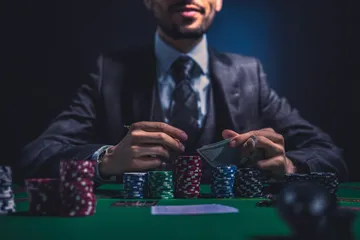 Um homem comemorando uma vitória em seu laptop enquanto símbolos de jogos flutuam ao redor, capturando a emoção dos jogos 01 BET.